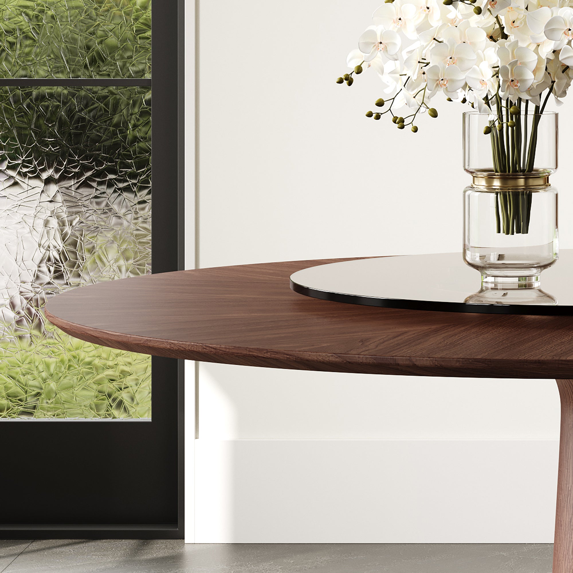 Close-up of the walnut tabletop edge and brown glass turntable with an orchid vase