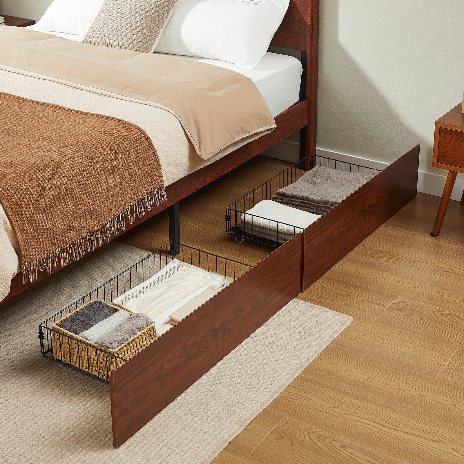 Two side storage drawers pulled out under dark reddish-brown burl wood bed, holding folded towels and baskets #Color_Natural