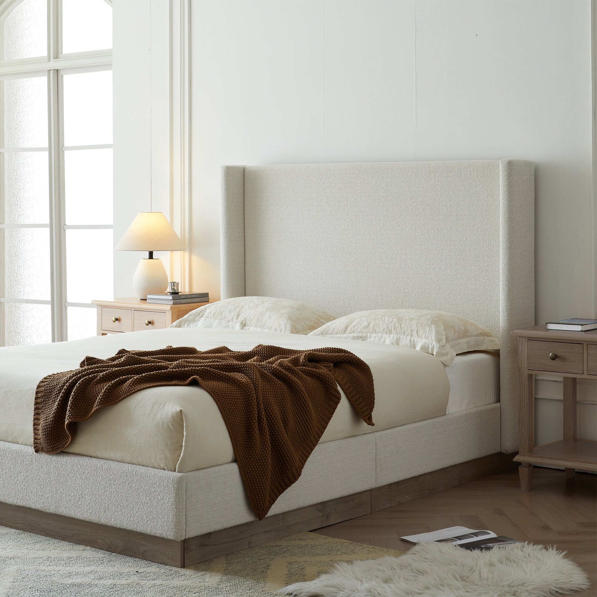 Close-up of wood leg on cream upholstered bed frame corner