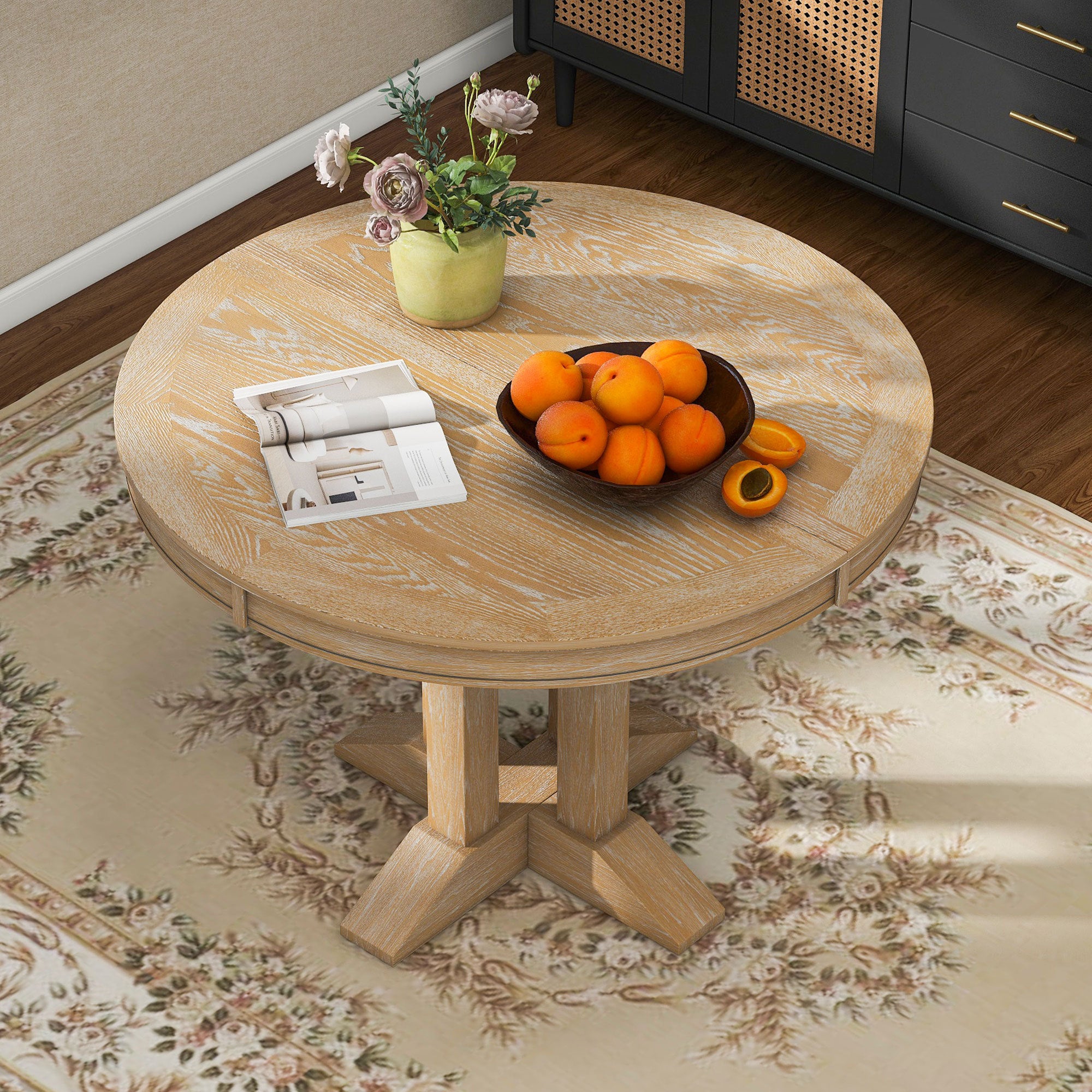 Natural oak round dining table in a sunlit styled room