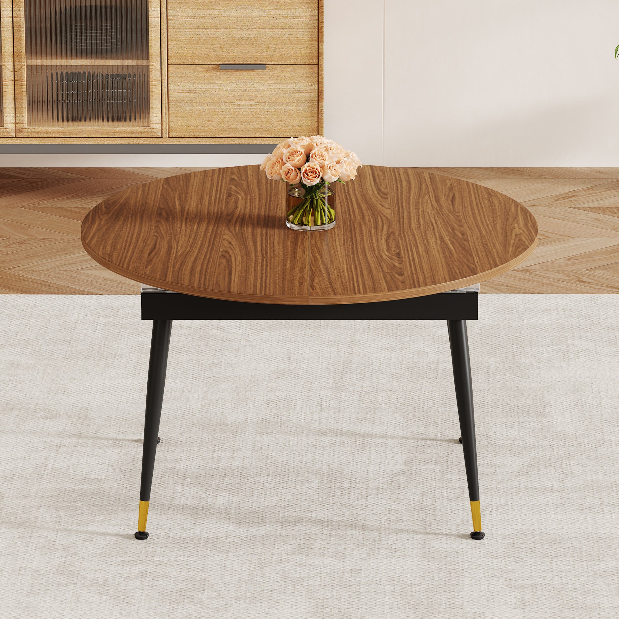 Front view of walnut oval extendable table with roses in front of a fluted glass cabinet