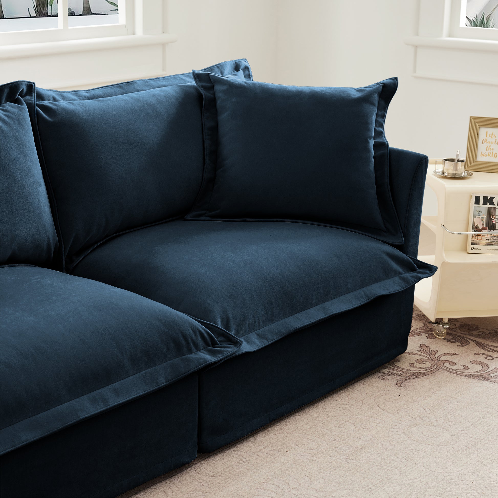 Angled end shot of the navy chenille sectional, highlighting the deep seat, plush back cushion, and soft textured slipcover with modular, pet-friendly design.