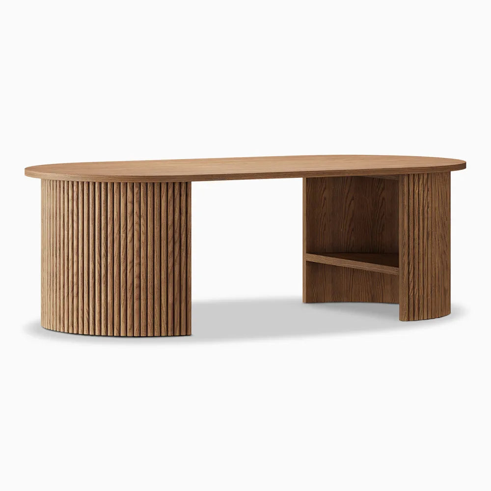 Angled perspective of a wood coffee table with fluted legs and a smooth oval top, showcasing its sculptural base and open side support.