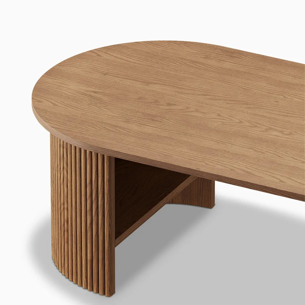 Angled View of a fluted wood coffee table leg with an oval shape and curved edge, showing the underside support panel.