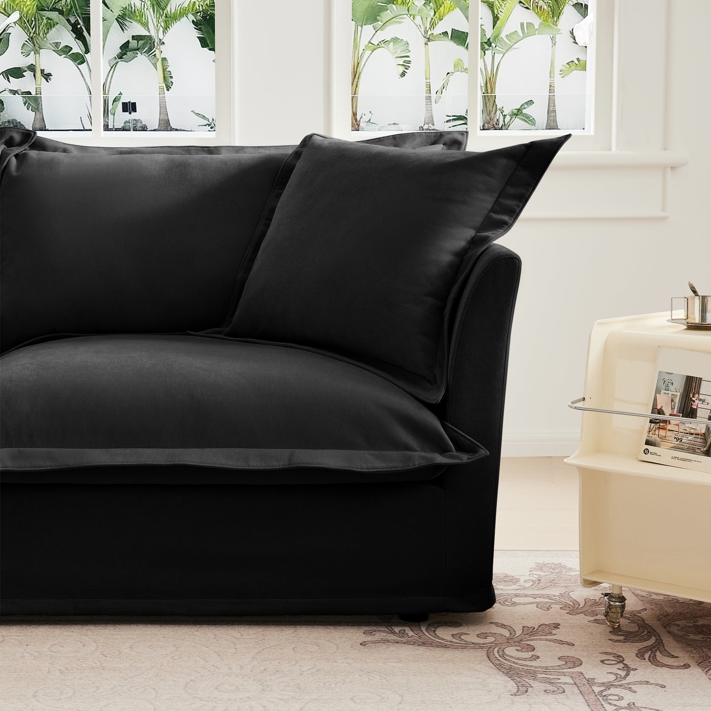 Close-up detail of the end of a fluffy black chenille sectional sofa — showcasing the soft textured armrest, plush cushion, and clean stitching with removable, washable slipcover for easy maintenance.