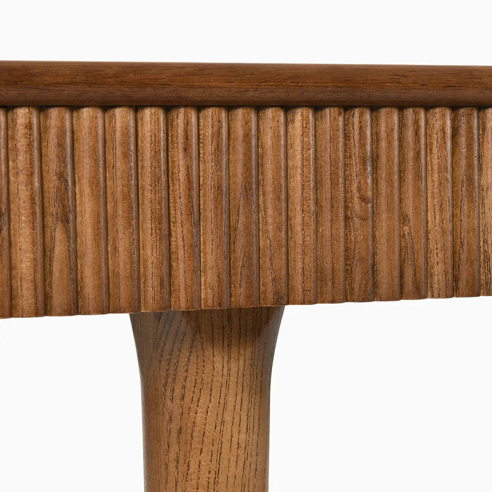 Close-up of vertical fluted detailing on ash wood dining table, highlighting mid-century design and warm brown wood finish.