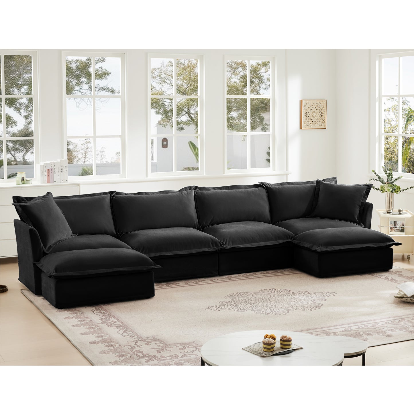 Lifestyle image of a fluffy black chenille sectional sofa with two ottomans arranged in a contemporary living space — showcasing its plush cushions, deep seats, and soft, machine-washable slipcovers for a cozy, lived-in feel.