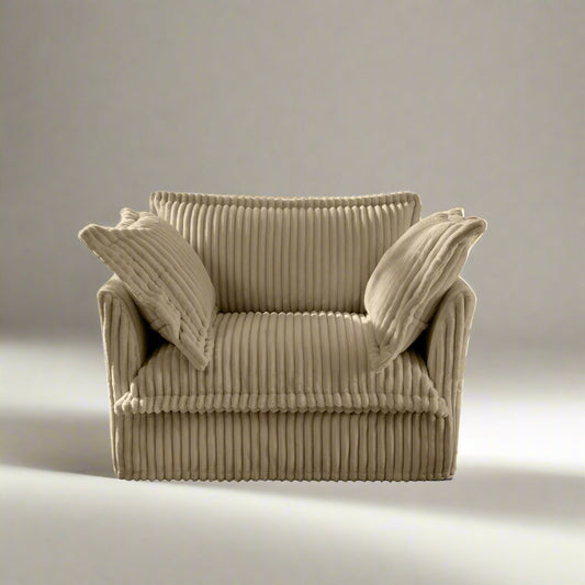 studio photography of the fluffy chair in camel color with corduroy fabric showing two large pillows and the comfortable fabric texture