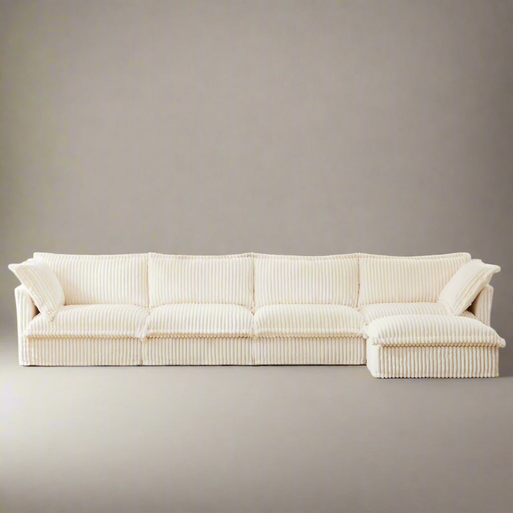 Cream-colored 4-seat couch made of soft, fluffy corduroy fabric, shown with a matching ottoman. The couch features a cozy, inviting texture and comes with washable covers.