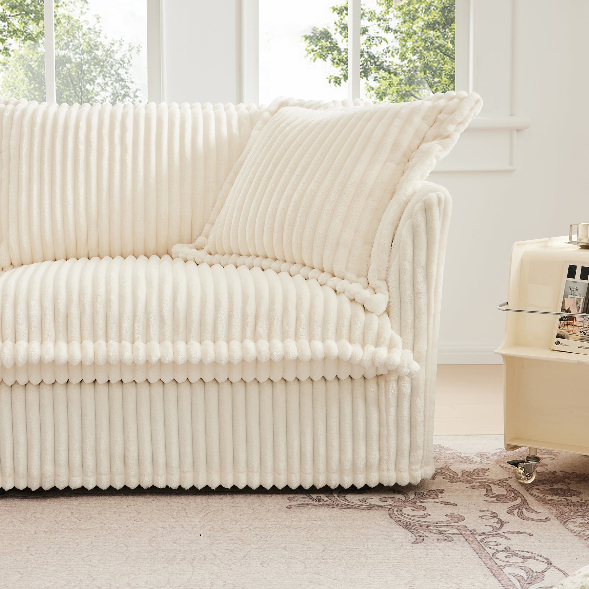 Frontal corner view of a cream corduroy couch, showing its soft, plush texture, deep seating, and removable, washable covers for easy cleaning and comfort.