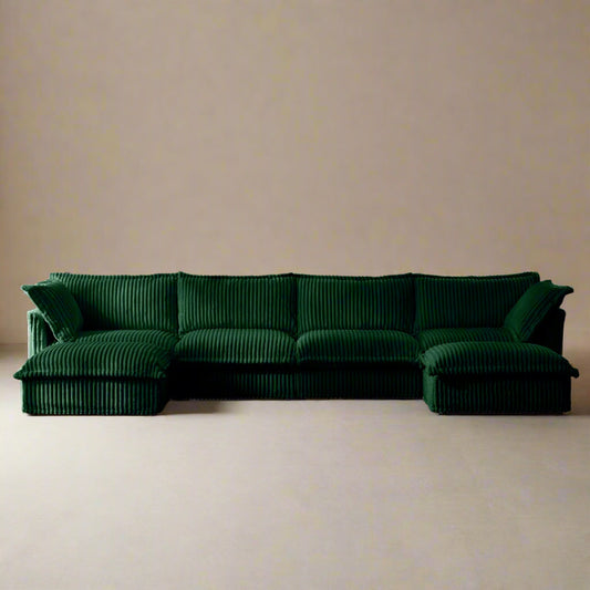 Front-facing studio view of a 4-seat emerald green corduroy sectional with two ottomans, featuring deep seats, modular L or U shaped layout options, plush cushions, and machine washable, pet-friendly slipcovers.