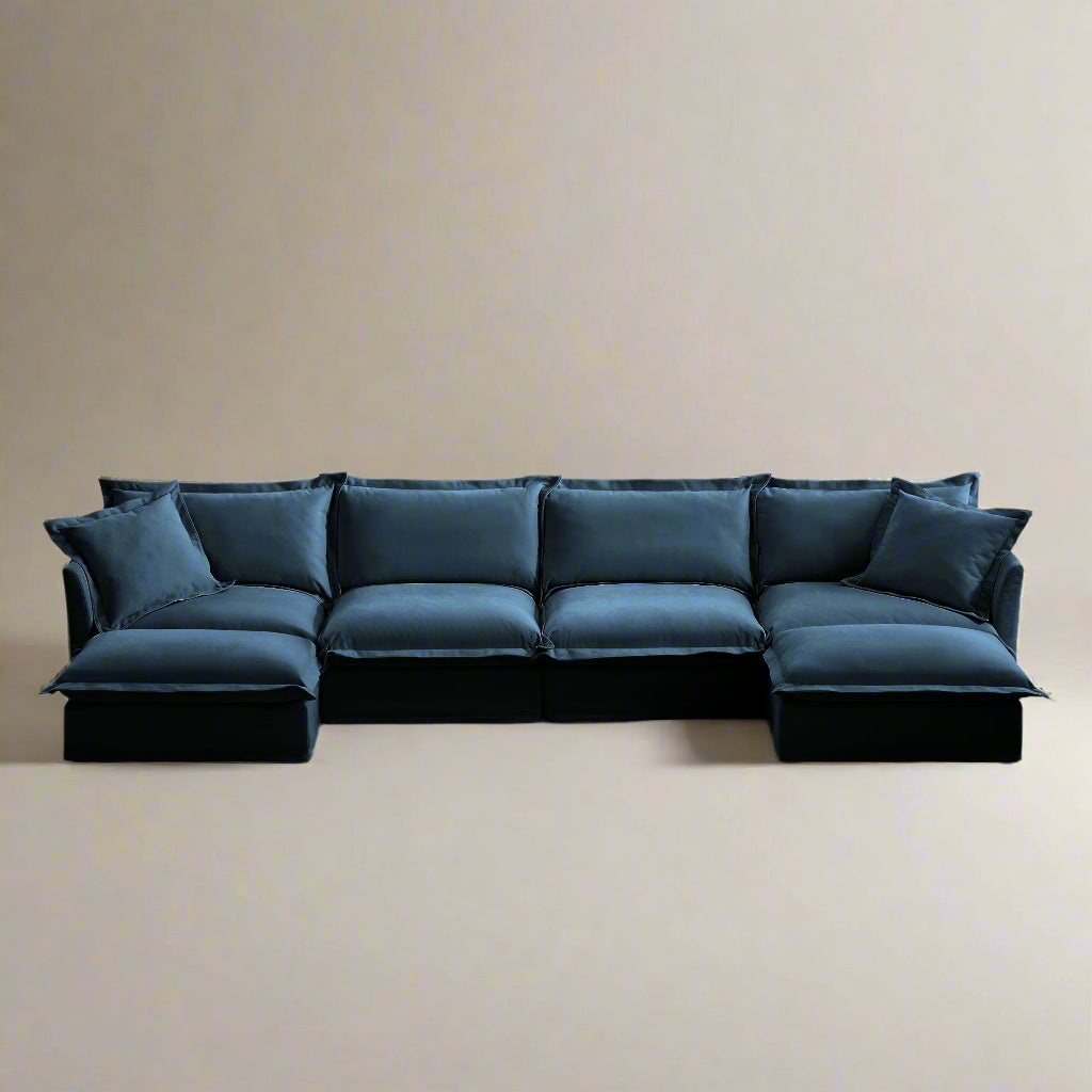 Angled view of a navy blue 4-seat chenille sectional sofa with two ottomans, showcasing its modular L-shaped layout, plush deep seats, and removable, machine washable slipcovers.