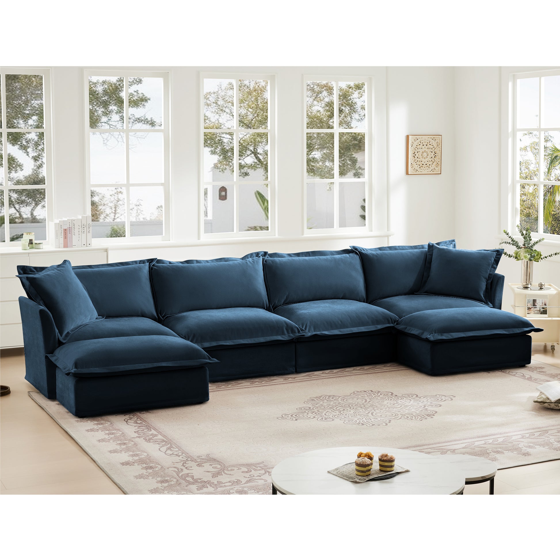 Lifestyle scene of a navy blue 4-seat chenille sectional with two ottomans styled in a cozy living room, highlighting its deep cushions, modular layout, and pet-friendly washable slipcovers.