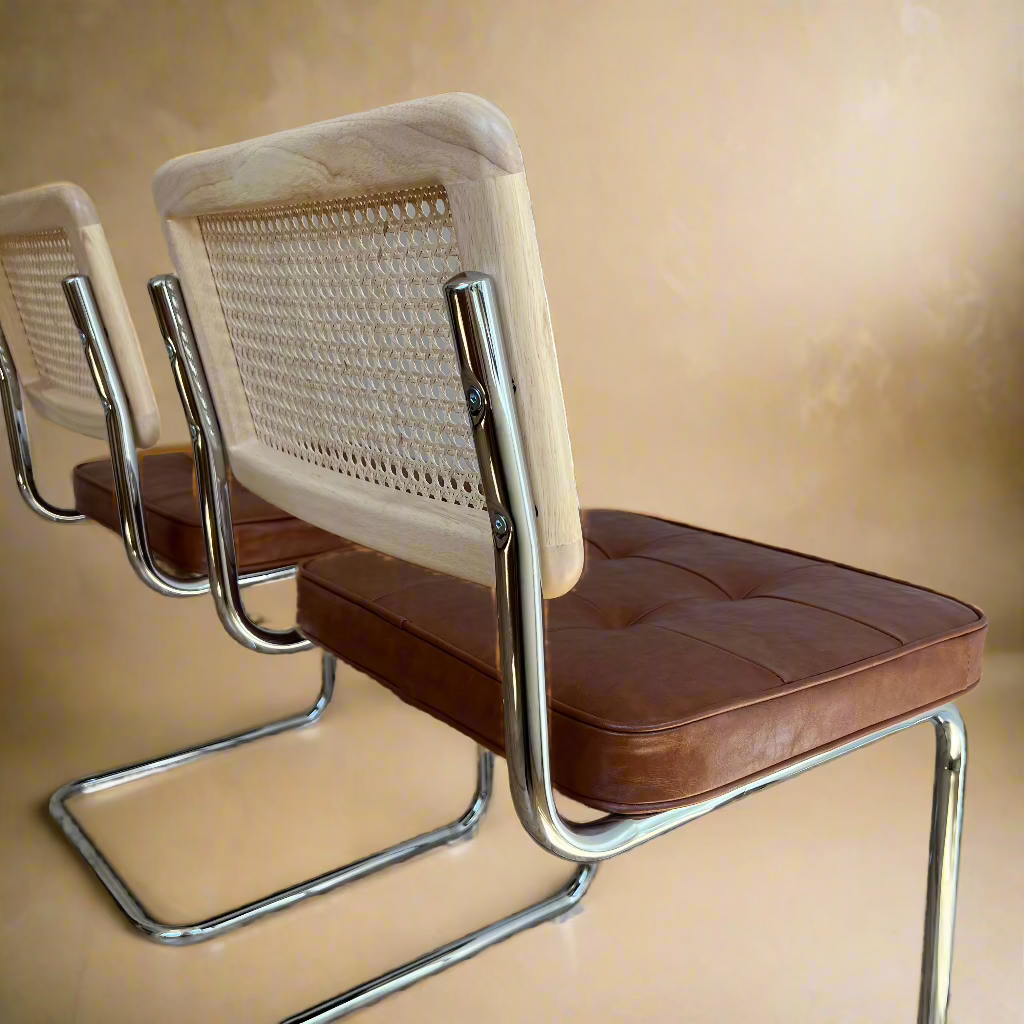 Rattan Dining Chairs – Set of 2 with brown vegan leather seats, accent rattan backs, and chrome metal legs.