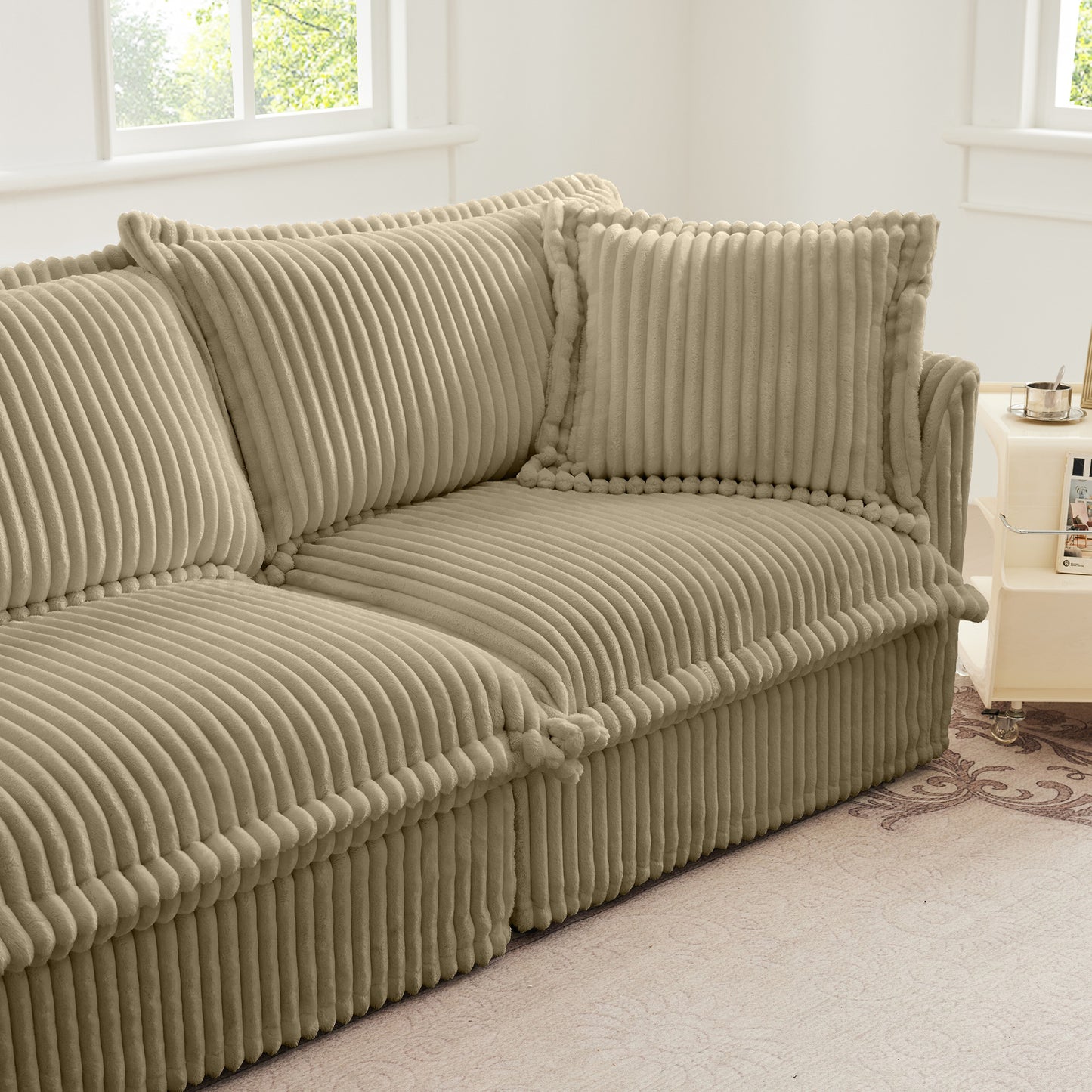 Close-up side view of the fluffy camel corduroy sectional featuring the armrest, matching throw pillow, and plush seat cushion, all wrapped in soft, wide-wale textured fabric.