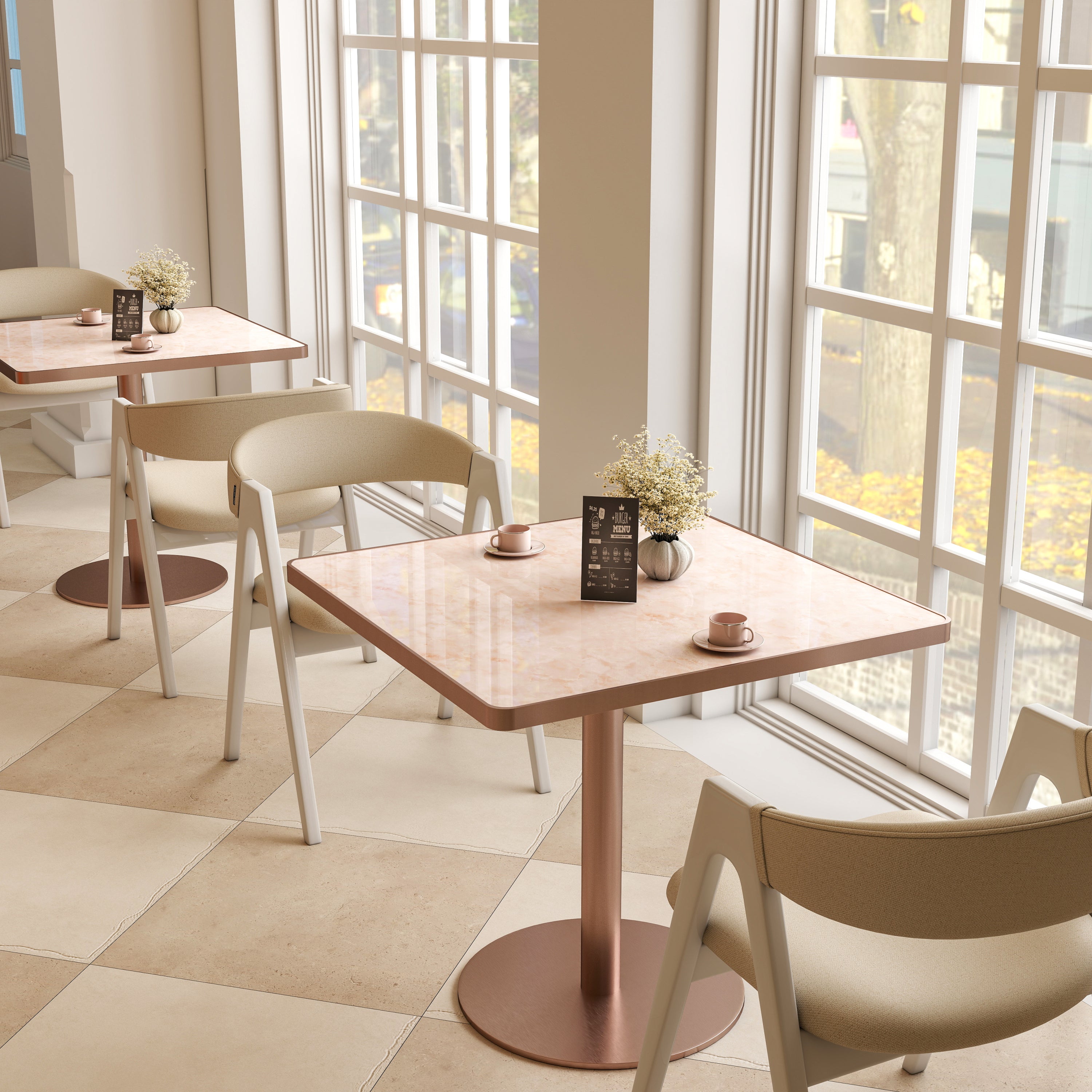 Pink and rose gold square tables in a sunlit cafe by tall windows with woven chairs