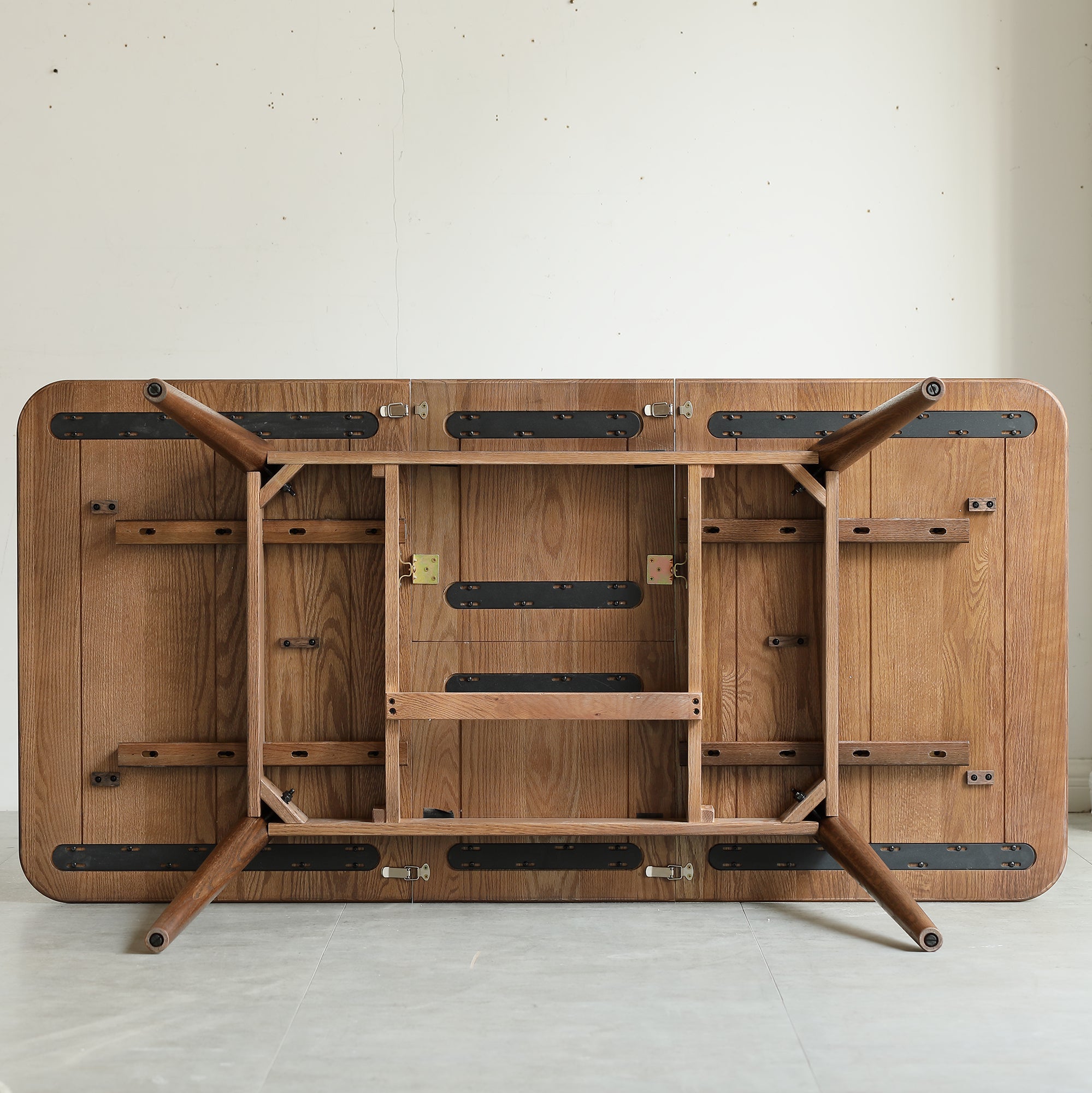 Underside of the walnut oak table showing the frame, extension slide rails and folding legs