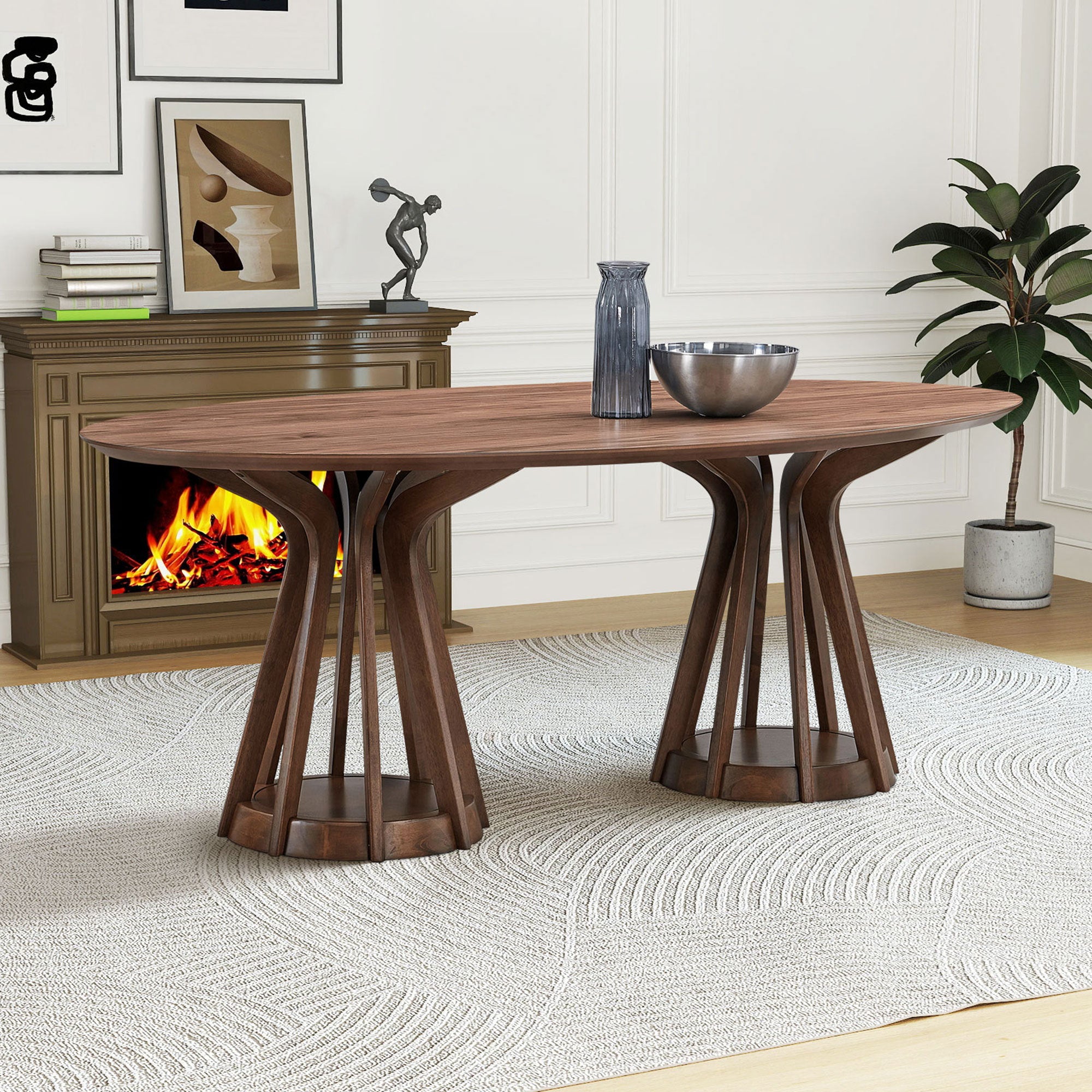 Walnut oval pedestal dining table styled by a fireplace with vase and bowl on top