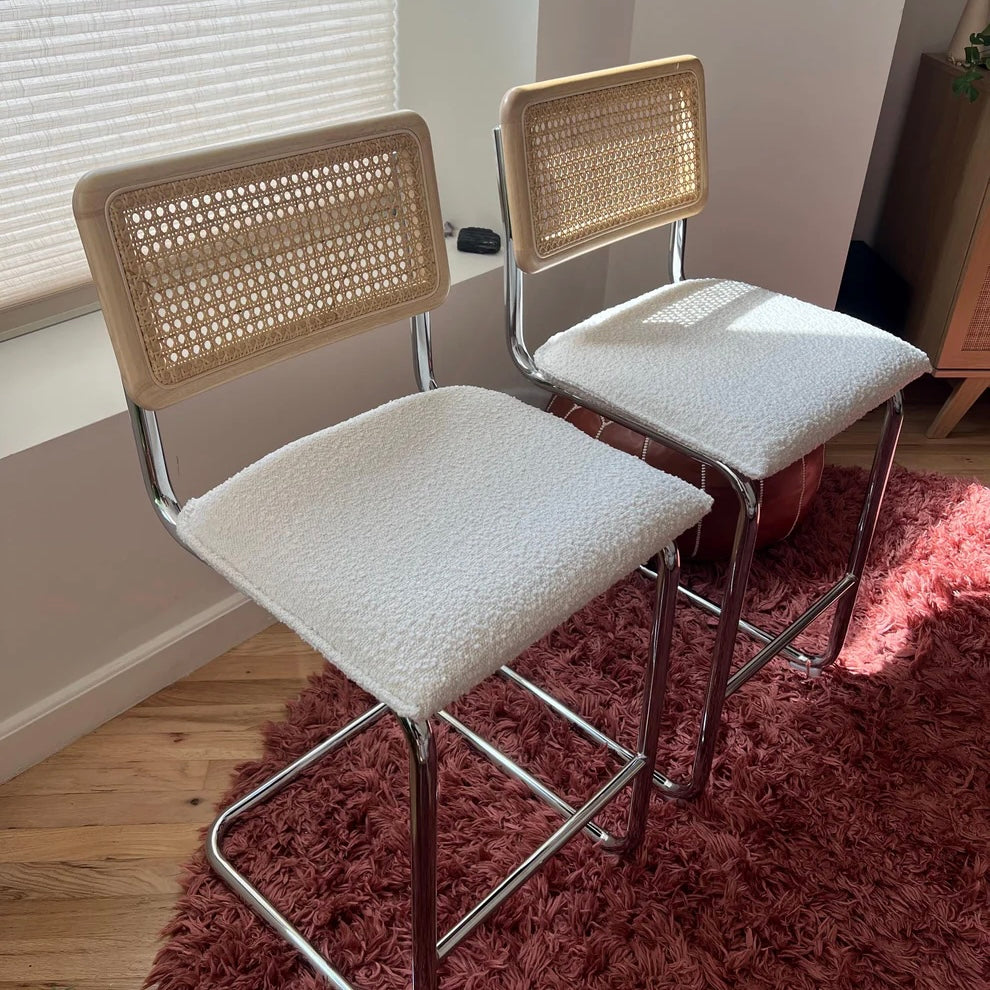 Midcentury Modern Counter Stools Set of 2 with white bouclé seats, rattan backs, and stainless steel legs