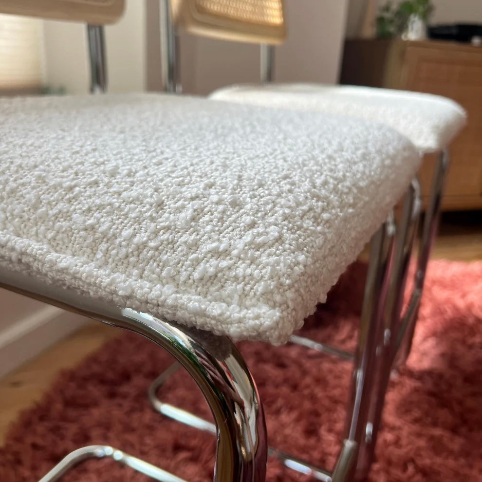 Midcentury Modern Counter Stools Set of 2 with white bouclé upholstery and stainless steel legs on a red rug.