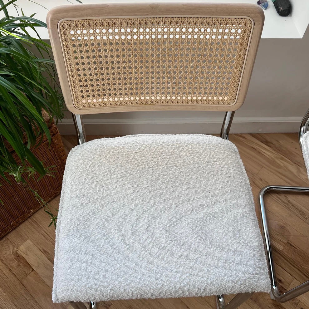 overview of white boucle seat with solid wood and rattan backrests on modern dining chair