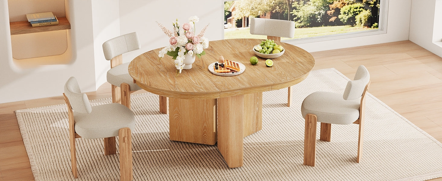 Angled view of the extended oval oak table set with four cream chairs