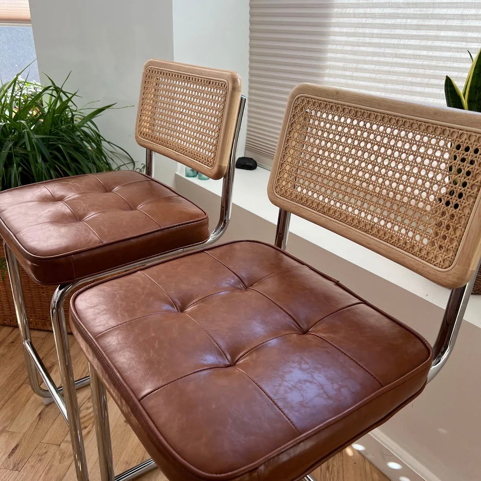 side view of counter height bar stools with vegan leather seats stainless steel frames and solid wood and rattan backs for a 36 inch counter