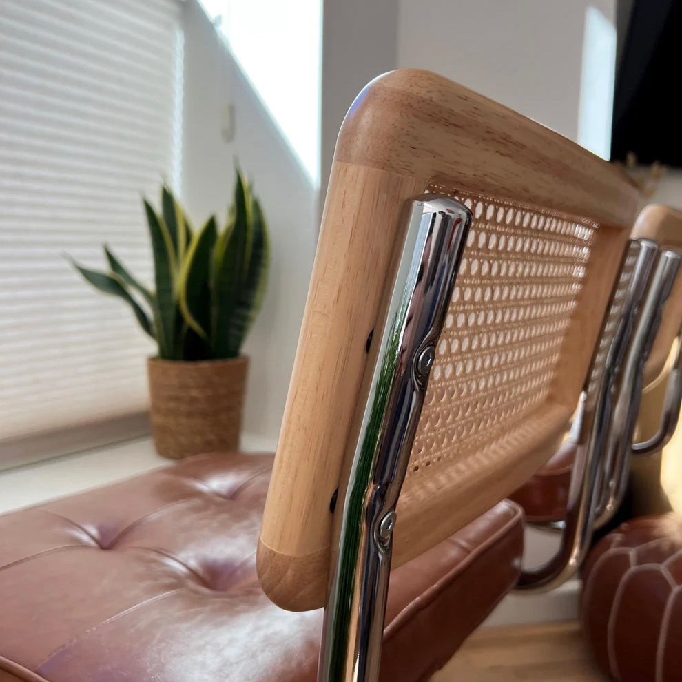 closeup of stainless steel frame attached to solid wood backrest on a counter height bar stool in mid century modern style