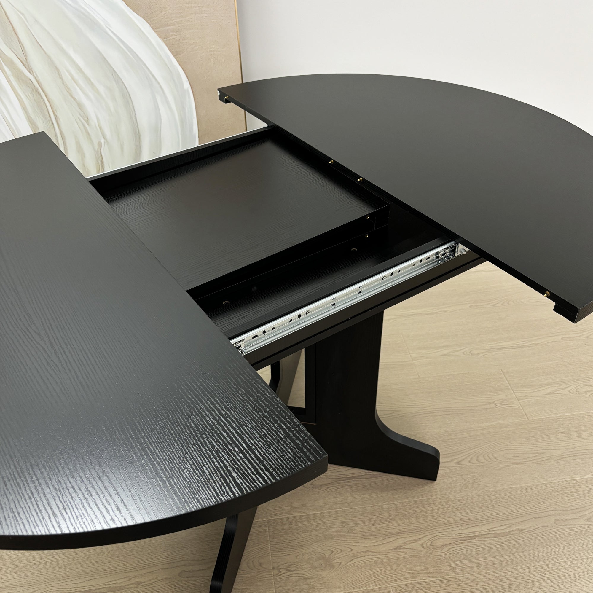 Close-up of the metal extension slide rails between the separated black tabletop halves