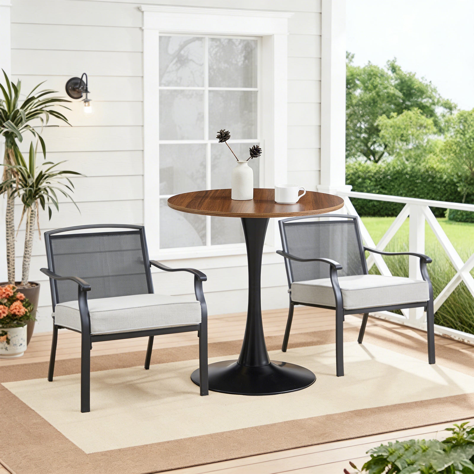 Dark wood-grain round bistro table on a porch between two gray patio armchairs