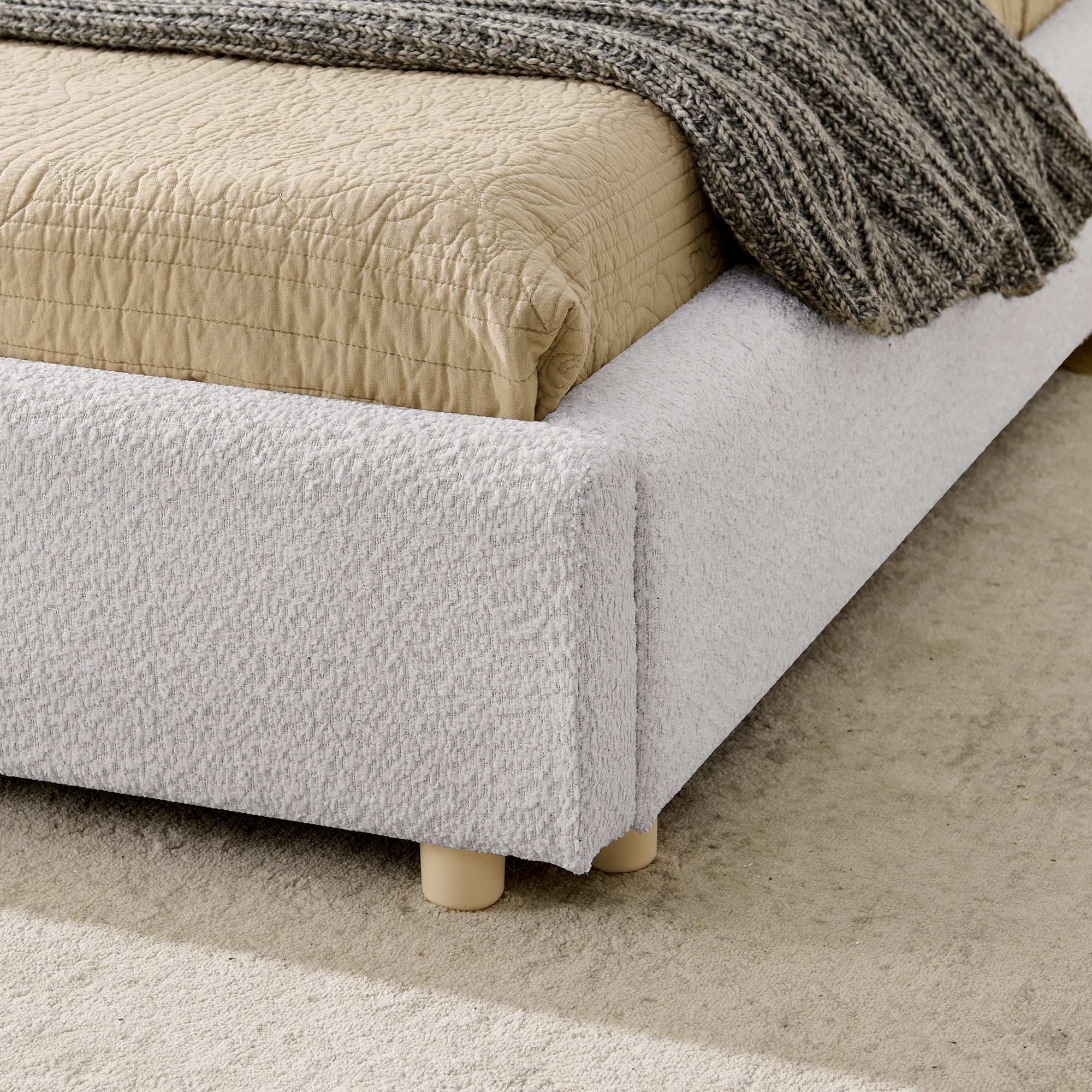 Close-up of upholstered frame corner and wood leg on carpet