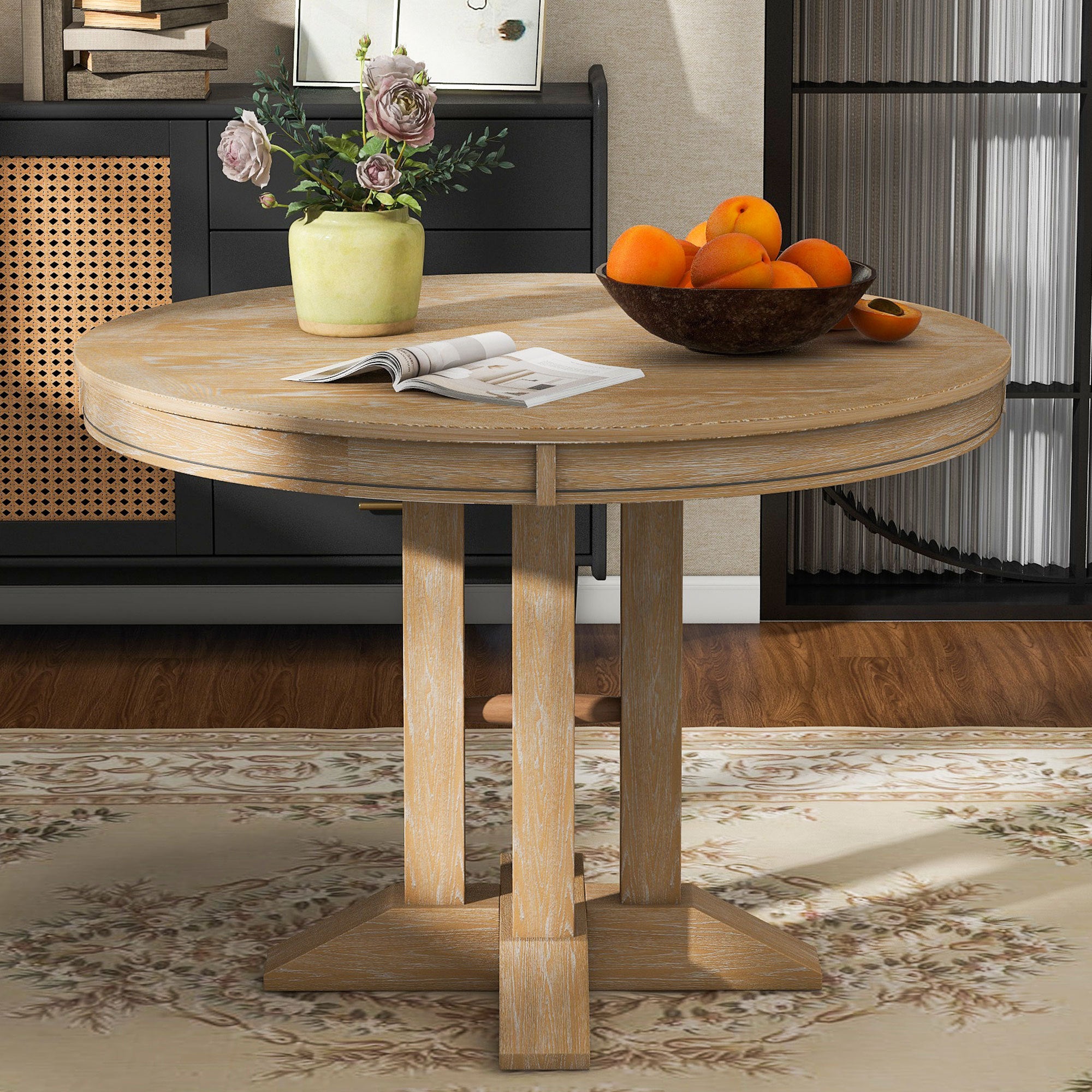 Natural oak round dining table styled in a room with a black cane sideboard