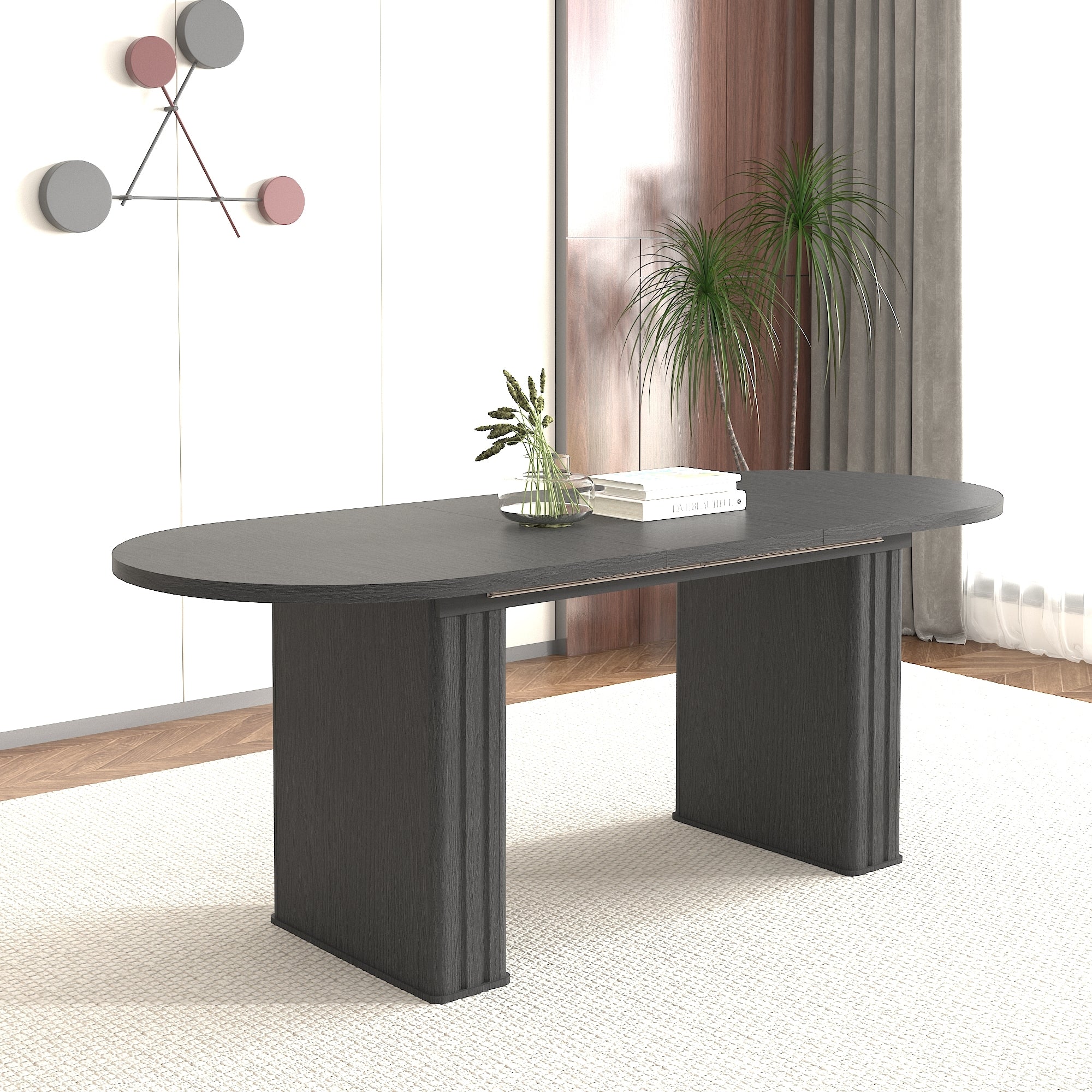 Angled view of the black oval extendable dining table in a bright room with a tall potted plant