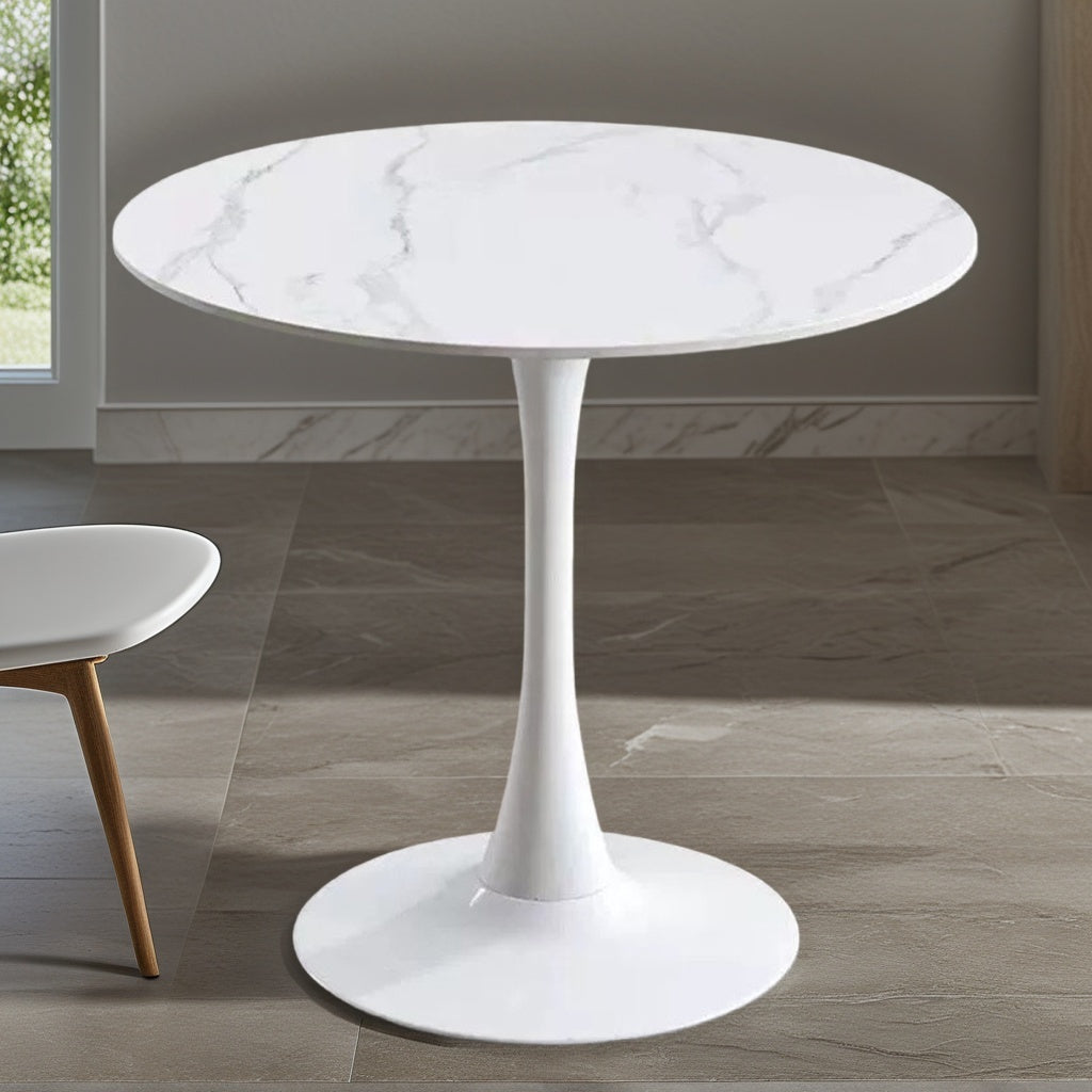 White marble tulip bistro table near a window with an accent chair, three-quarter view