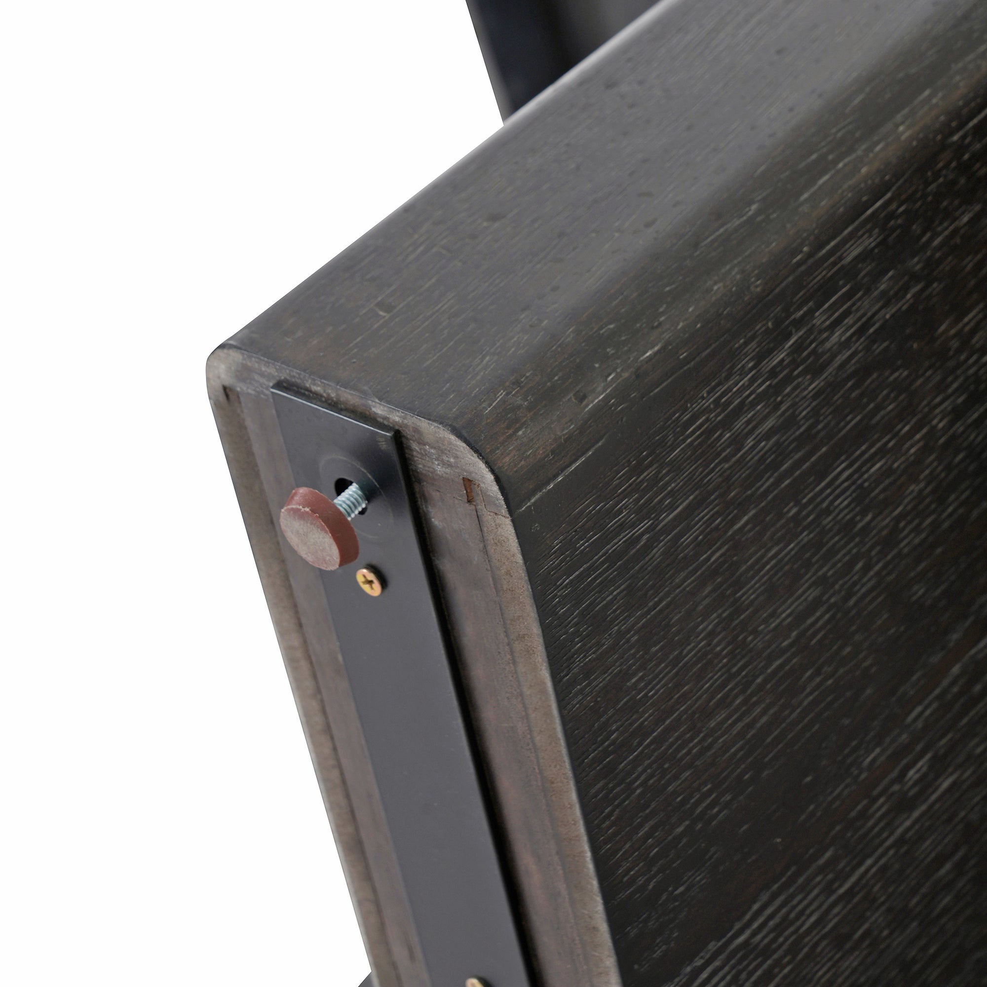 Close-up of a corner underside showing the black bracket and brown bolt cap