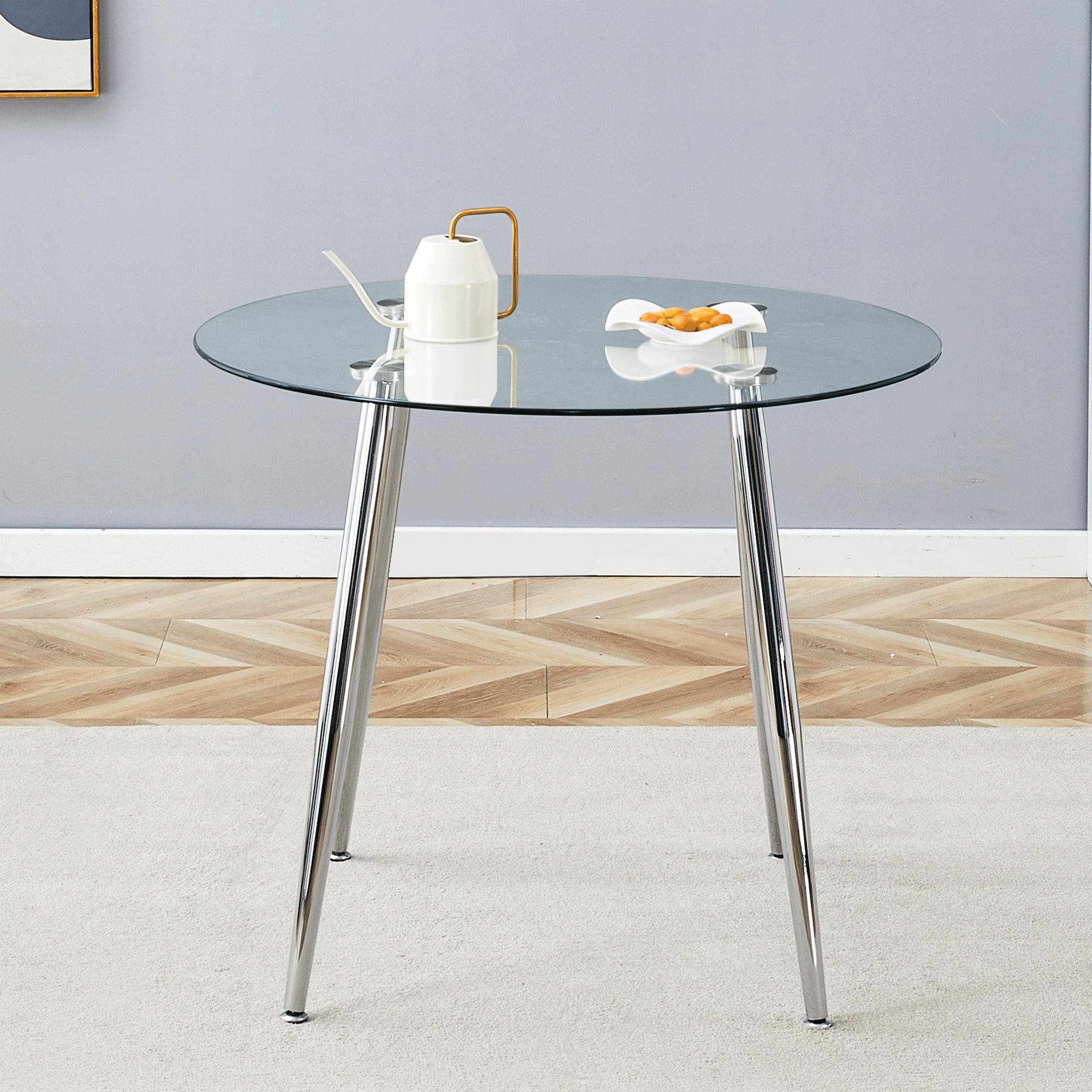Round glass dining table with silver metal legs shown straight on in a styled room