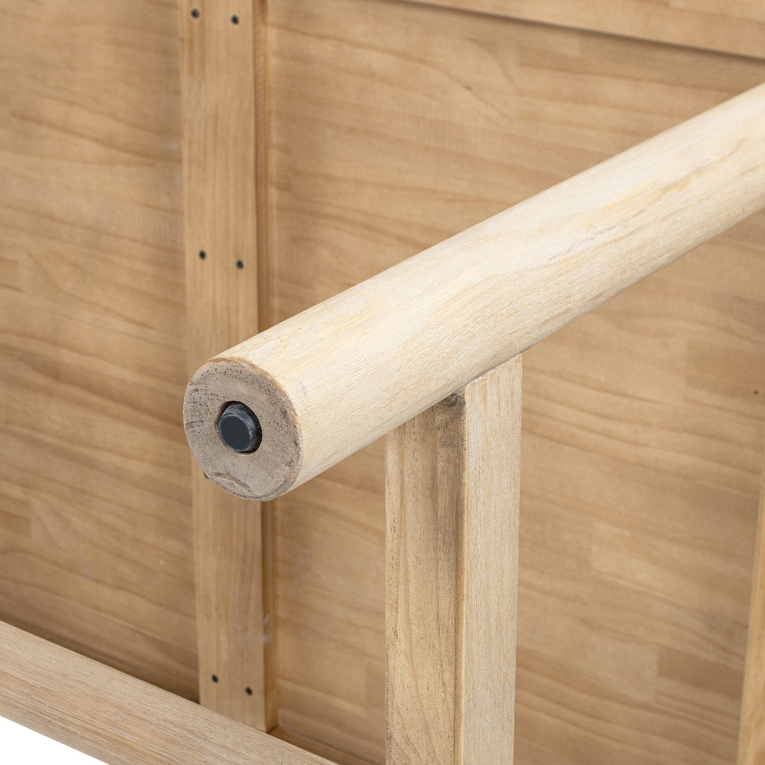 Close-up of an underside stretcher joint with a wood dowel and metal pin