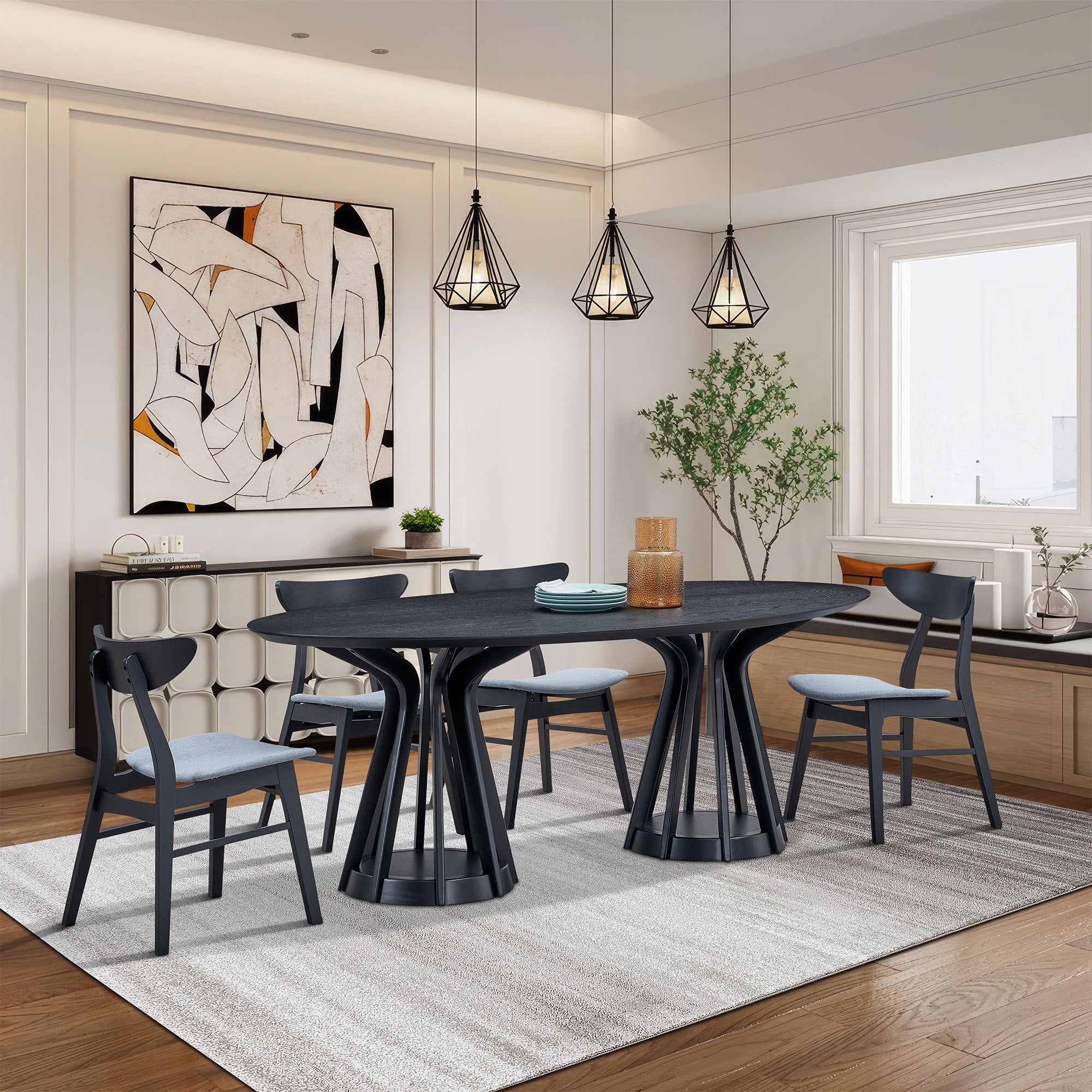 Black oval pedestal dining table with four chairs under pendant lights in a room