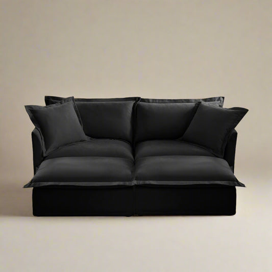 Front view of a black 2-seat chenille modular sofa with deep cushions two ottomans and four pillows showing the machine washable slipcovers