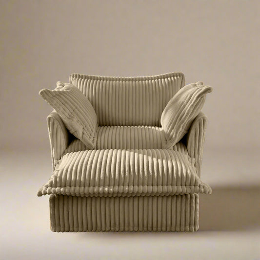 studio shot of the fluffy chair in camel colored corduroy upholstery showing the corduroy ridges rich texture plush pillows and deep wide seat