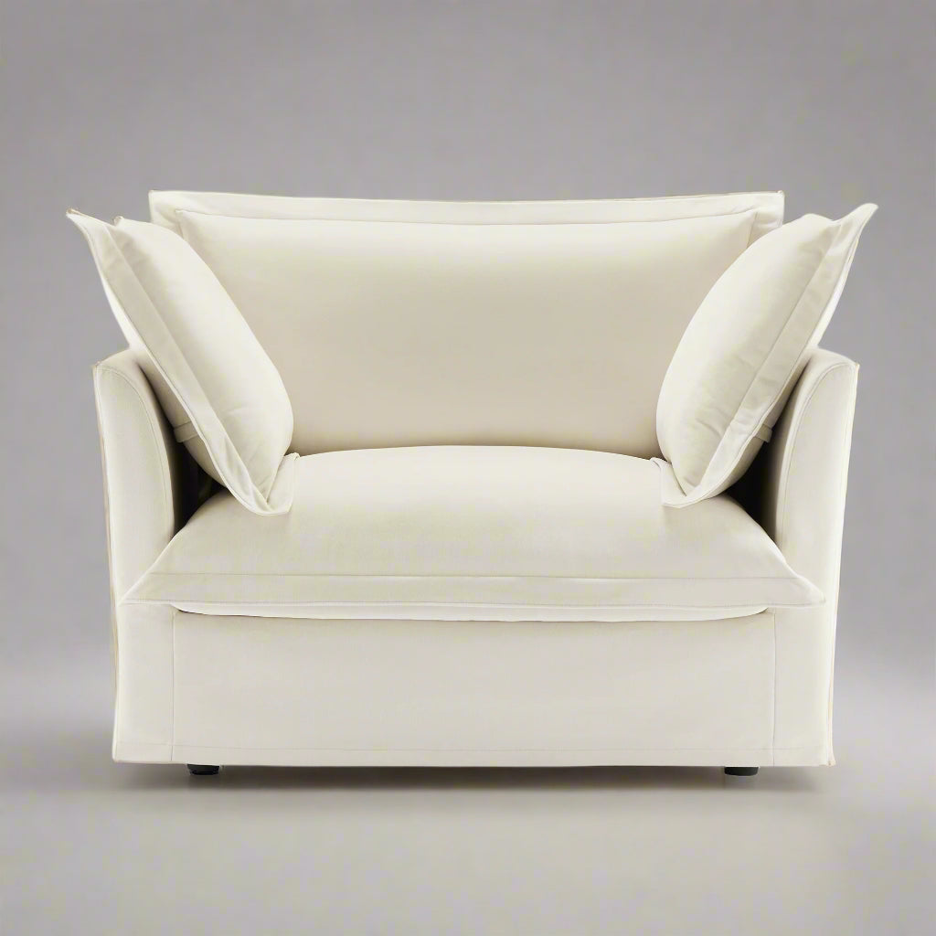 closeup shot of the big fluffy chair in cream chenille showing the plush pillows and rich upholstery texture as well as the wide and deep seat