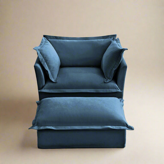 studio shot of the fluffy chair in navy chenille upholstery with an ottoman in front. Showing the plush pillows and deep seat for maximum comfort