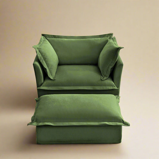 closeup of the fluffy chair in olive chenille showing the rich color armrests and plush pillows and seating the ottoman is in front of the chair and shows how wide and deep the seat is