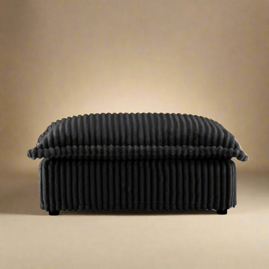 closeup shot of the fluffy ottoman showing the rich black corduroy upholstery and plush seat
