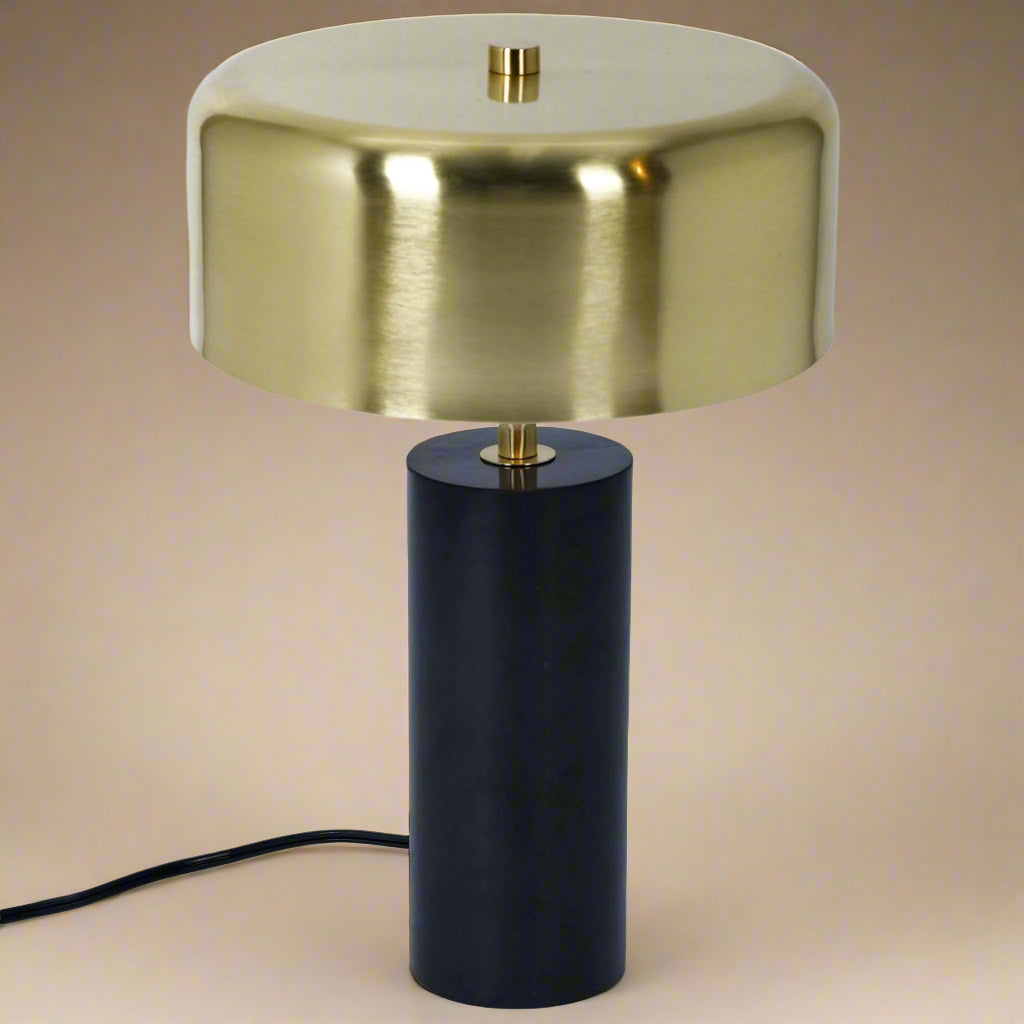 overview of gold shade table lamp showing black marble base and gold stem with cord showing
