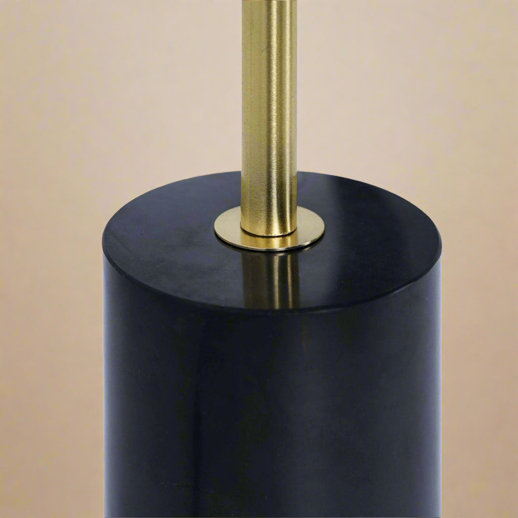 closeup of where the gold stem meets the black marble base on a table lamp