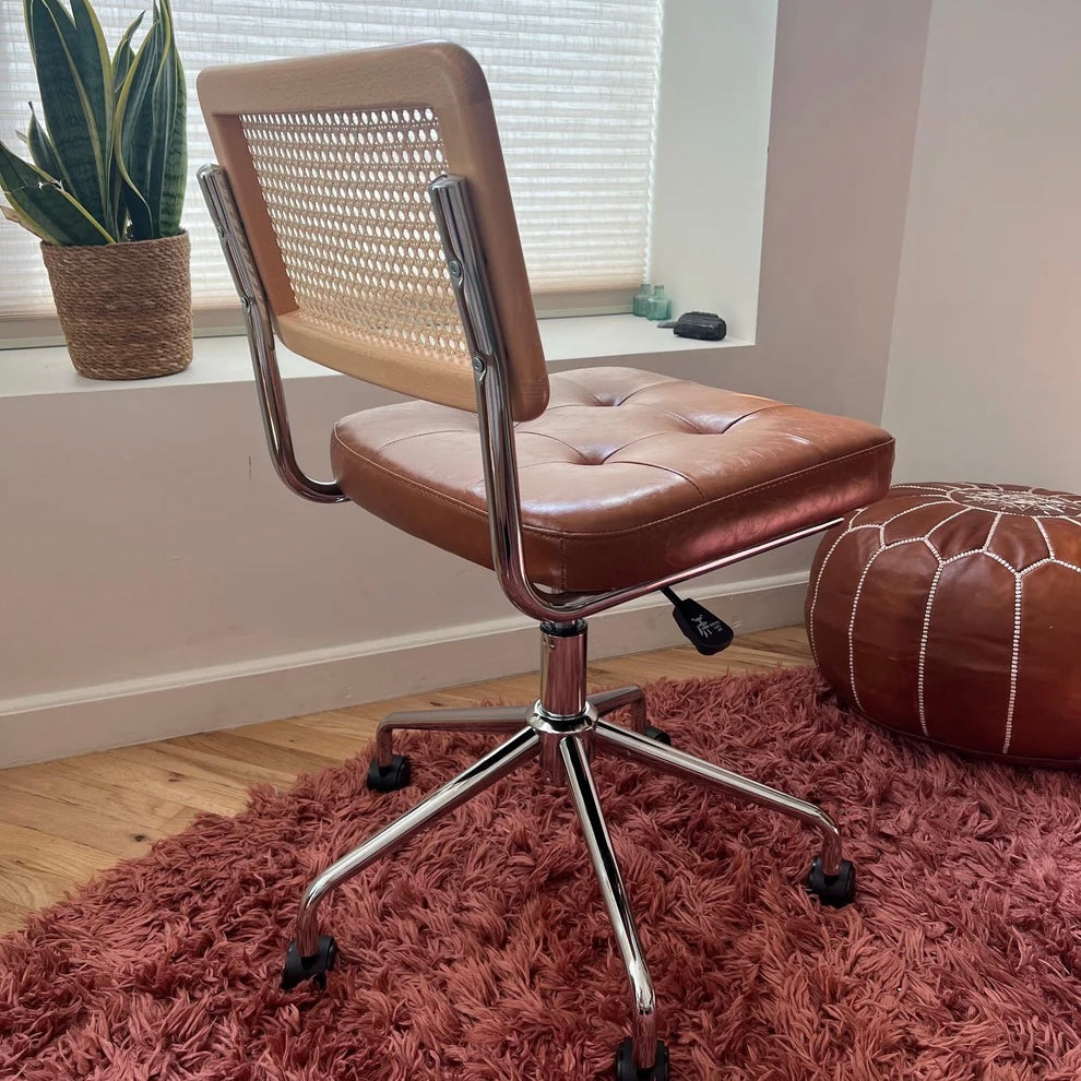 rear quarter angle of mid century modern office chair with brown vegan leather seat and solid wood rattan backrest