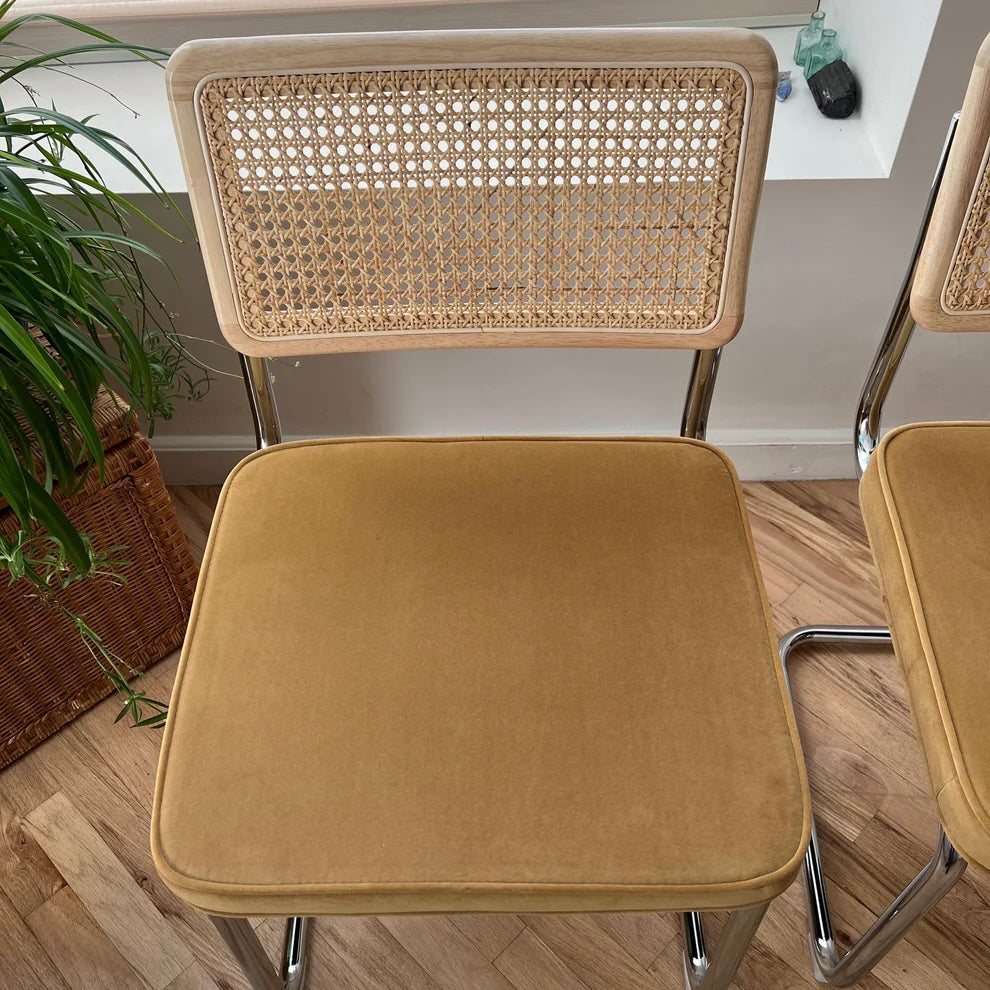 overview of dining chair with yellow velvet seat and wooden backrest with rattan