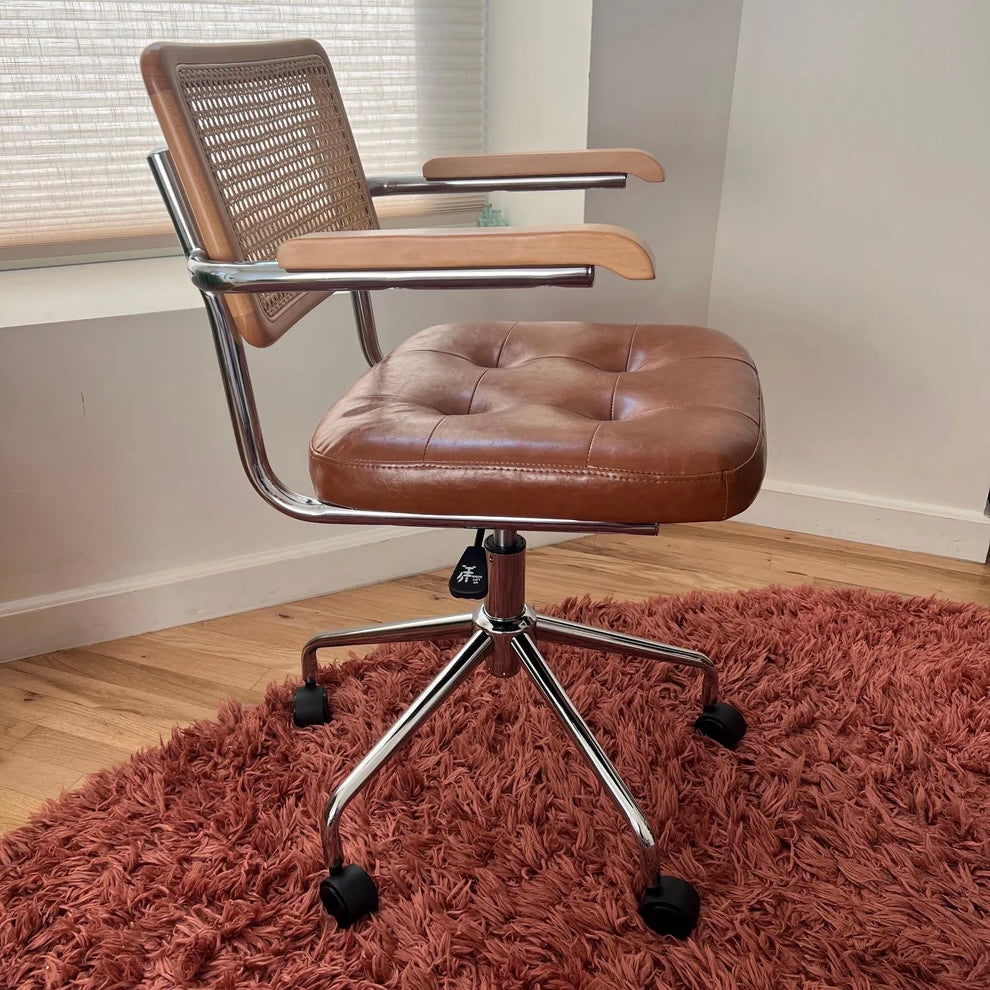 side profile view of mcm office chair with brown vegan leather seat and solid wood armrest and backrest