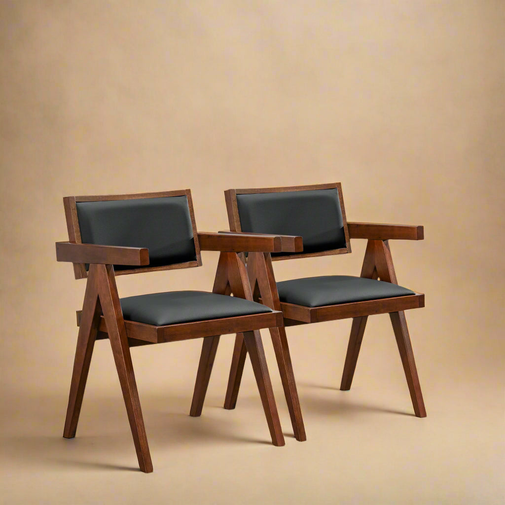 three quarter view of solid wood black vegan leather dining chairs showing the beautiful coloration of the wood